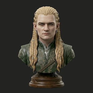 Pode incluir: Busto detalhado de um elfo com longos cabelos loiros trançados e orelhas pontudas. A figura usa uma túnica verde semelhante a couro com detalhes prateados e um pingente decorativo. O busto é montado em uma base de madeira.