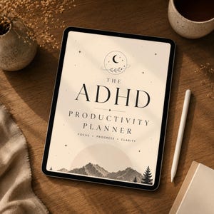 Pode incluir: Um tablet digital exibindo "The ADHD Productivity Planner" com um gráfico de montanha e árvore. Uma caneta branca e uma xícara de café estão em uma superfície de madeira. O design do planejador inclui um motivo de lua crescente e estrela.