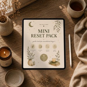 Pode incluir: Um tablet digital exibe o texto "MINI RESET PACK" com a frase "gentle tools for overwhelmed days." O tablet é cercado por uma vela, uma xícara de chá, uma tigela pequena e elementos decorativos em uma superfície de madeira.