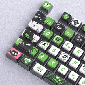 May include: A collection of custom keyboard keycaps in various colors and designs. The keycaps feature a mix of black, green, white, and pink, with unique graphics and symbols. Some keycaps display letters, numbers, and symbols, while others showcase anime-style illustrations and decorative elements.