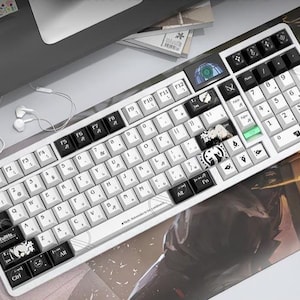 May include: A white mechanical keyboard with black and white keycaps. The keyboard has a number pad and a small screen. The keycaps feature various symbols and designs. A white mouse and earbuds are also visible.
