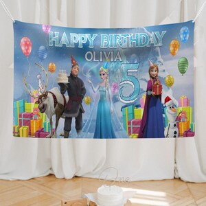 May include: A birthday banner featuring characters from the movie Frozen. The banner reads "Happy Birthday Olivia" with a large number "5". Colorful balloons and wrapped gifts decorate the scene. Characters include Elsa, Anna, Kristoff, Olaf, and Sven.