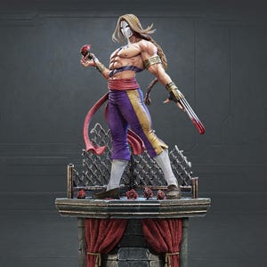 Puede incluir: Estatua detallada de una figura musculosa con pelo largo y rubio, una máscara blanca y pantalones morados con detalles dorados. La figura sostiene una rosa roja y tiene un arma con tres cuchillas. La estatua se alza sobre una plataforma decorativa con rosas y una cortina roja.