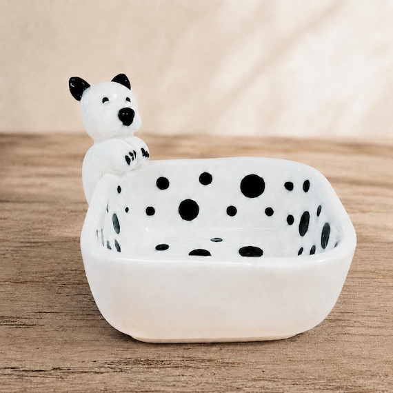 A hand-sculpted ceramic dish shaped like an actual dog — not just dog-printed, dog-formed, making it a genuinely artisan object.