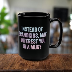 May include: Black coffee mug with white text that reads "Instead of grandkids, may I interest you in a mug?"