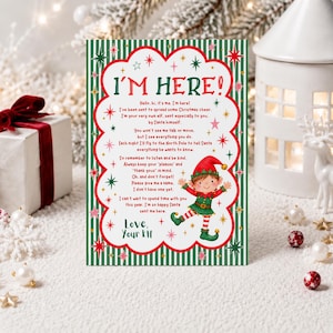 May include: A rectangular Christmas card with a green and white striped border, featuring a red scalloped frame containing the text I'M HERE! and a poem about an elf. A cartoon elf in a red and green outfit stands on the right side.
