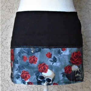 May include: Black and gray skull and rose print fabric skirt with a black waistband.