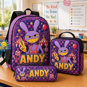 May include: A purple backpack, lunch bag, and pencil case set featuring a cartoon rabbit character, carnival tents, and the name ANDY in yellow letters. The items have a purple and dark purple checkered pattern with stars and lollipops.