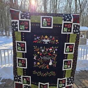 Puede incluir: Un edredón con temática navideña con un fondo negro e imágenes festivas. El edredón presenta cuadrados con diseños navideños, incluyendo regalos, corazones y pájaros. El centro muestra el texto "the most wonderful time of the year."