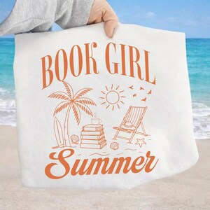 Op de afbeelding: Een witte draagtas met een oranje grafische print met de tekst BOOK GIRL Summer. Het ontwerp bevat een palmboom, een stapel boeken met een kopje, een zon, vogels, een strandstoel, een surfplank, schelpen en een zeester op het zand.