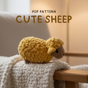 May include: A handmade, yellow crochet sheep with a textured body and brown face and ears. The sheep is on a white, fluffy blanket. The image includes the text "PDF PATTERN" and "CUTE SHEEP".