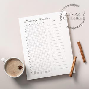 Könnte beinhalten: Ein weißes Lesetracker-Blatt mit einem Raster zur Verfolgung des Lesefortschritts, dem Text "Reading Tracker" und dem Text "A5 • A4 • US Letter". Eine Tasse Kaffee mit Sternanis und zwei Zimtstangen sind ebenfalls vorhanden.