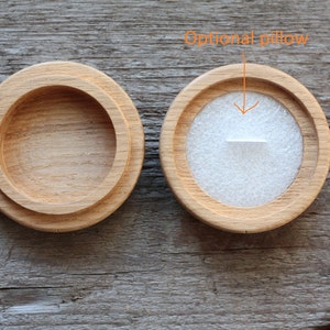 Puede incluir: Dos cajas de madera para anillos, una con una almohada de terciopelo blanco en el interior. La caja con la almohada est&aacute; etiquetada como "Almohada opcional".