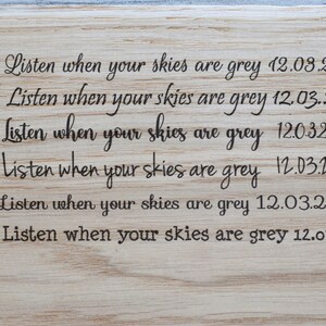 May include: A wooden sign with the text "Listen when your skies are grey" repeated six times, each with a different date: 12.08.2024, 12.03.2024, 12.032024, 12.03.2024, 12.03.2024, and 12.03.2024.