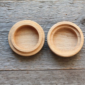 Puede incluir: Dos cajas redondas de madera con tapas. Las cajas son de madera marr&oacute;n claro y tienen un acabado liso. Las tapas est&aacute;n ligeramente elevadas y tienen un borde redondeado.