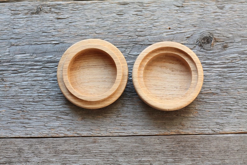 Puede incluir: Dos cajas redondas de madera con tapas. Las cajas son de madera marr&oacute;n claro y tienen un acabado liso. Las tapas est&aacute;n ligeramente elevadas y tienen un borde redondeado.