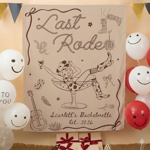 May include: A beige tapestry with the words "Last Rodeo" in a rope-like font, featuring a cowgirl in a martini glass. The tapestry includes illustrations of a snake, dice, a guitar, and a disco ball. The text "Scarlett's Bachelorette Est. 2026" is also present.
