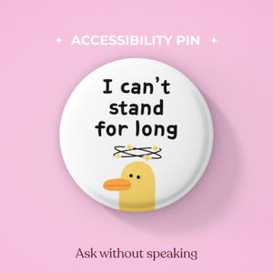 以下が含まれることがあります： 白い円形のピンバッジ。中央には黒い文字で「I can't stand for long」と書かれ、その下にはオレンジ色のくちばしを持つ黄色いアヒルのイラストが描かれています。アヒルの頭上には小さな黄色い星が散りばめられた黒い円形のグラフィックがあり、背景はピンク色です。