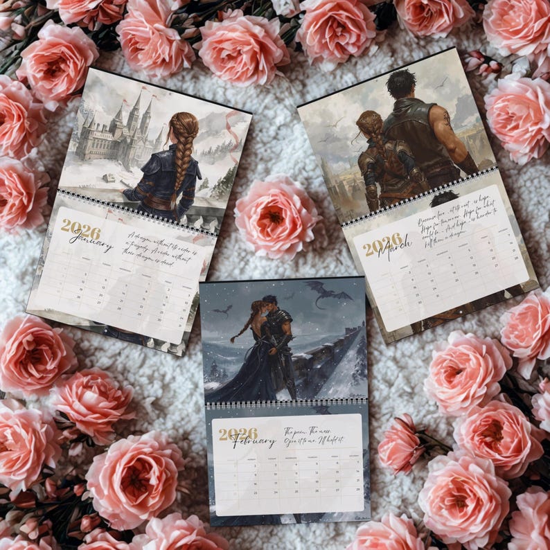May include: Three 2026 wall calendar pages featuring fantasy illustrations of characters in armor and gowns, with one page showing a castle, another a couple, and the third a pair in a snowy landscape, all surrounded by pink roses.