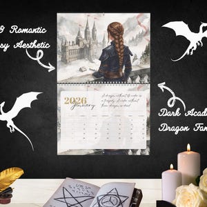 May include: A 2026 wall calendar featuring a fantasy illustration of a person with a braided hairstyle looking at a castle. The calendar page displays the text 2026 January and a quote about dragons. White dragon silhouettes, candles, a quill, and an open book with star symbols are arranged around the calendar.