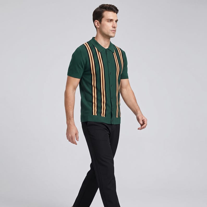 Op de afbeelding: Een groene polo met korte mouwen met verticale strepen in bruin, geel en rood. Het shirt is dichtgeknoopt en wordt gedragen met een zwarte broek. De persoon loopt.