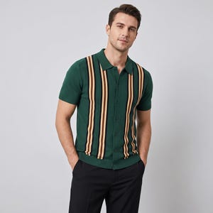 Op de afbeelding: Groen poloshirt met korte mouwen en verticale strepen in bruin, beige en zwart. De shirt heeft een knoopsluiting aan de voorkant en een kraag. Het model draagt een zwarte broek. De shirt is gemaakt van een gebreide stof.