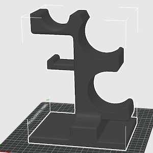 May include: A black, three-bottle wine rack. The rack has a rectangular base and a central support with curved holders for the bottles. The design is modern and minimalist, suitable for kitchen or bar decor.