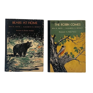 Pode incluir: Dois livros infantis vintage. O primeiro, "Bears at Home", apresenta uma ilustração de um urso negro. O segundo, "The Robin Comes", mostra um robin a alimentar os seus filhotes. Ambos os livros têm texto e ilustrações.