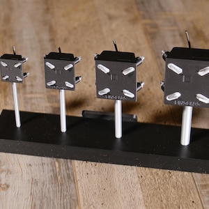 May include: A set of three ceramic mugs with a speckled, matte finish. Each mug is a different colour: light blue, cream, and grey. The mugs have a simple, modern design, ideal for coffee or tea.