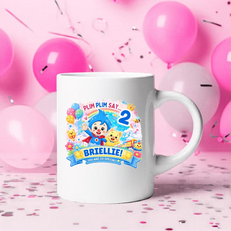 May include: A white ceramic mug featuring a colorful graphic of the character Plim Plim, a rainbow, balloons, and the number 2. The text reads PLIM PLIM SAY... BRIELLIE! YOU ARE SO SPECIAL! The design includes a small yellow creature and a train.