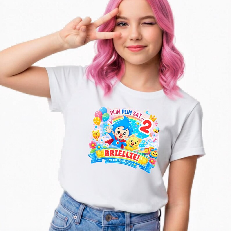 May include: A white short-sleeved t-shirt featuring a colorful graphic of the cartoon character Plim Plim, a yellow cat, a rainbow, balloons, and the text "PLIM PLIM SAY...", "BRIELLIE!", "YOU ARE SO SPECIAL!", and the number "2" in red.