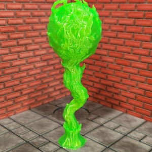 May include: A neon green, abstract sculpture with a bulbous top and a twisting, stem-like base. The sculpture has a textured surface and is set against a brick wall and tiled floor.