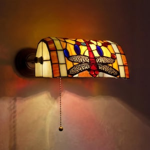 May include: A white ceramic mug with a black handle and the text "But First, Coffee" in a black, bold font. The mug is on a white surface.