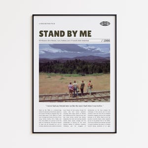 Puede incluir: Un póster de película enmarcado para "Stand By Me" con un borde negro. El póster presenta el título de la película, el elenco y el año 1986. Una foto panorámica de cuatro chicos caminando sobre vías de tren está en el centro.