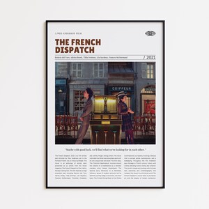 Puede incluir: Póster enmarcado de la película "The French Dispatch" de Wes Anderson. El póster presenta una escena con dos personas frente a una máquina de discos y una tienda. El título está en texto marrón y se muestra el año 2021.