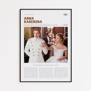 May include: Framed movie poster for "Anna Karenina" (2012) featuring Keira Knightley. The poster has a white background with the film title in large, bold text. The image shows two people in period costumes, a man in a white military-style jacket and a woman in a white dress.