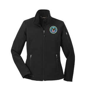 May include: Black zip-up jacket with a stand-up collar and multiple pockets. Features a circular emblem with an eagle and text. The jacket has a full-length zipper and a subtle logo near the hem.