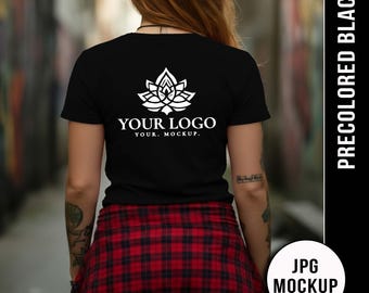 Op de afbeelding: Zwart T-shirt met een wit bloemenlogo en de tekst "YOUR LOGO. YOUR. MOCKUP." Een rood-zwart geruit overhemd is om de taille geknoopt. De afbeelding is gelabeld "PRECOLORED BLACK" en "JPG MOCKUP."