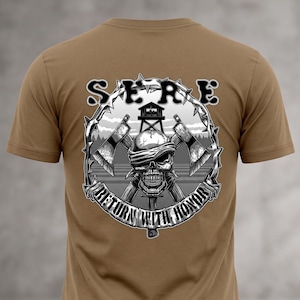 May include: A tan short-sleeve t-shirt featuring a graphic on the back. The design shows a skull with a blindfold, two crossed axes, and a guard tower, all enclosed in a barbed wire circle. The text reads SERE at the top and RETURN WITH HONOR below.