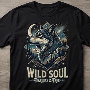 May include: Black t-shirt featuring a detailed illustration of a wolf's head with a crescent moon and starry sky background. The text "WILD SOUL" and "FEARLESS & FREE" are printed below the graphic. The design is set within a diamond shape.