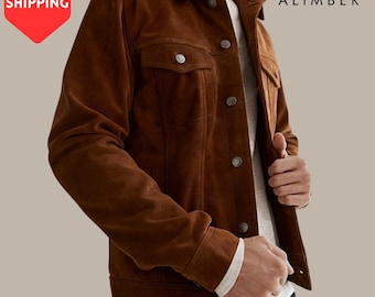 Peut inclure: Veste en daim marron avec des boutons argentés et deux poches de poitrine. La veste a un col classique et est portée sur une chemise blanche. La marque "ALIMBER" est visible dans le coin supérieur droit.