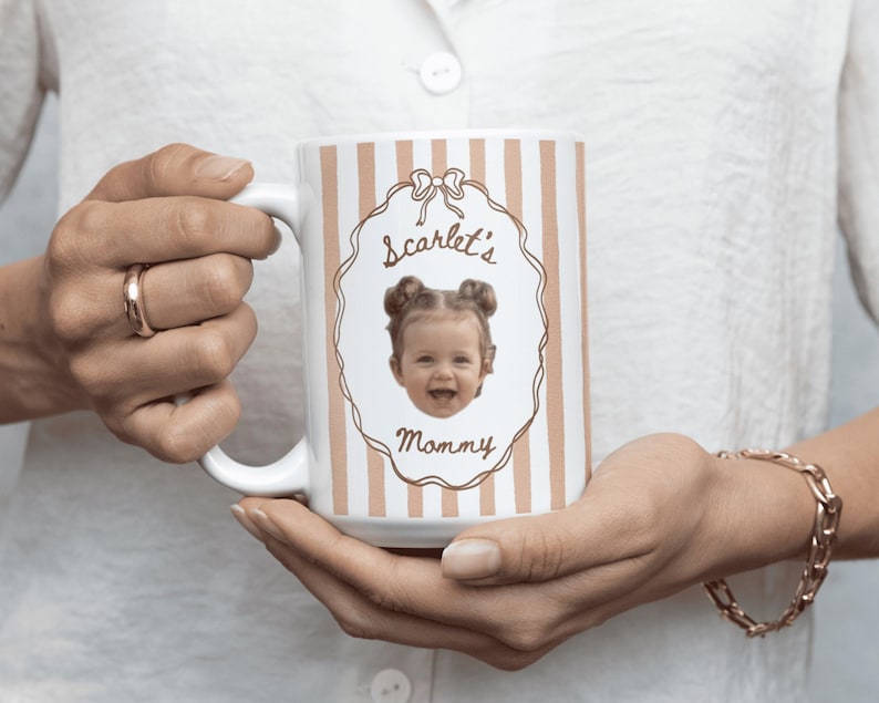 Personalized coffee mug with light brown vertical stripes, featuring a baby portrait with elegant floral frame, custom keepsake gift for Mom, Dad and grandparents