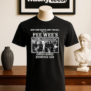 May include: Black t-shirt featuring a black and white image of a motorcycle club with the text "PEE WEE'S LONERS & REBELS MOTORCYCLE CLUB". The shirt also has the text "SENT FROM HEAVEN, BENT FOR HELL".