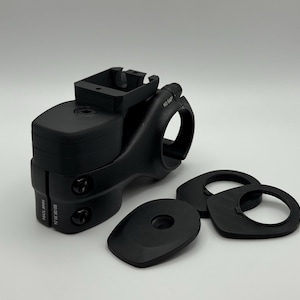 Pode incluir: Avanço de bicicleta preto com um suporte superior retangular e uma braçadeira circular. Inclui vários espaçadores pretos e uma placa frontal. O avanço tem o texto "MAX. ANN" e "30/36 NM" impresso na lateral.