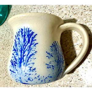 Mok met tabaksboomdesign uit 1982 van The Elements Pottery uit Danville, Kentucky.