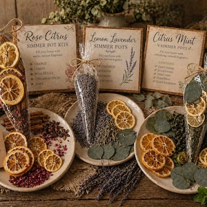May include: Three simmer pot kits with dried citrus, herbs, and spices. The kits are labeled "Rose Citrus," "Lemon Lavender," and "Citrus Mint." Each kit includes ingredients like orange slices, cinnamon sticks, and eucalyptus leaves. The text "Simple Natural Beautiful" is on a tag.