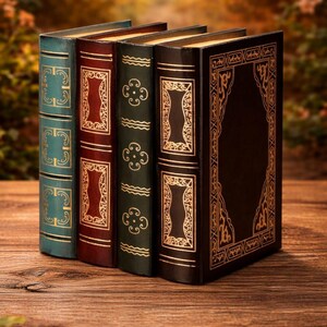 May include: Four antique books with ornate gold designs on their spines, standing upright on a wooden surface. The books are in teal, burgundy, dark green, and black, with gold accents. The background is a blurred view of a natural setting.