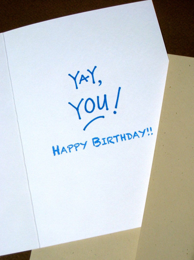 May include: A white card with blue ink that says "Yay, You! Happy Birthday!"