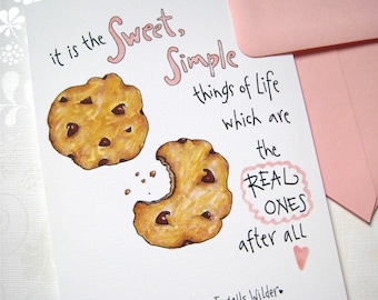 May include: A greeting card with a hand-drawn illustration of two chocolate chip cookies. The card features the quote "it is the Sweet, Simple things of Life which are the REAL ONES after all." The quote is attributed to Laura Ingalls Wilder.