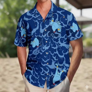 May include: A short-sleeved button-down shirt featuring a vibrant blue pattern with cartoon genie characters and swirling cloud designs. The shirt has a classic collar and wooden buttons. The genie is blue with gold accents and a red shoe.